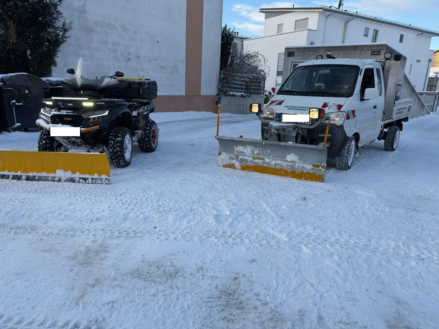 Räumfahrzeuge mit Schneeschild bei geräumter Zufahrt